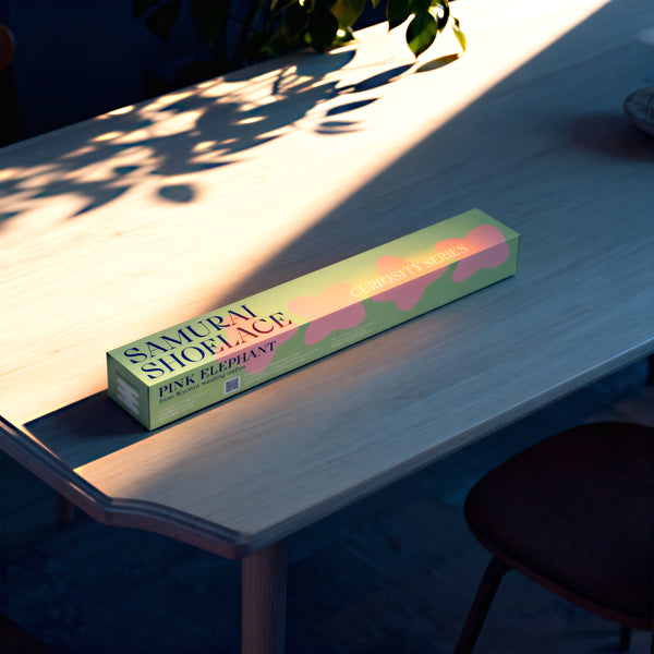 Samurai Shoelace Curiosity Series Pink Elephant kávékapszula termékfotója napfényes modern fa asztalon