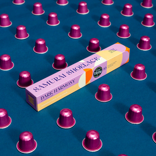 Samurai Shoelace Serious Coffee Dark Harmony kávékapszula termékfotója kék háttérrel rózsaszín kapszulákkal